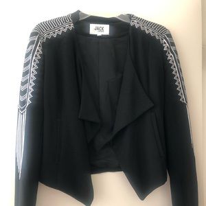 Black bolero style jacket with white embroidery.